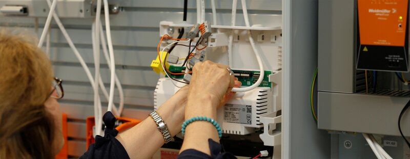 Woman wiring a control panel