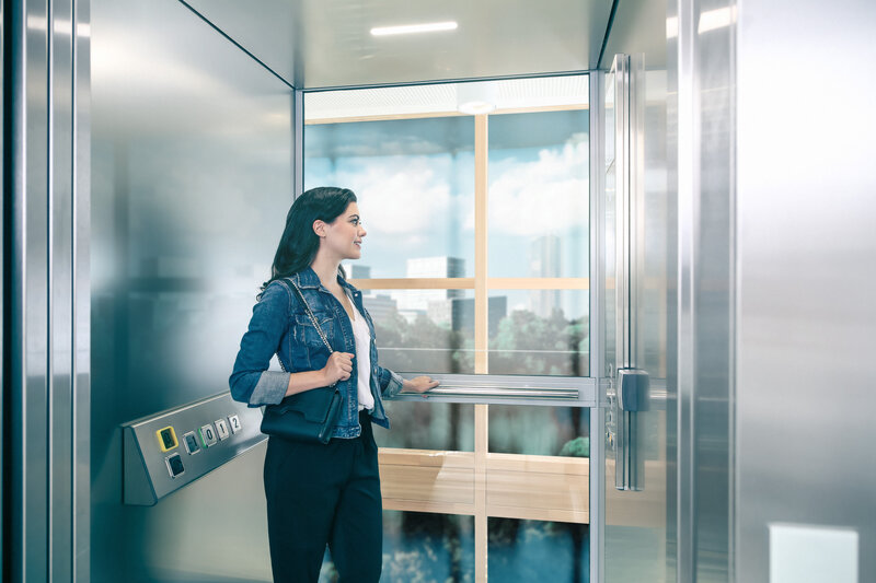 smiling woman standing in modern lift